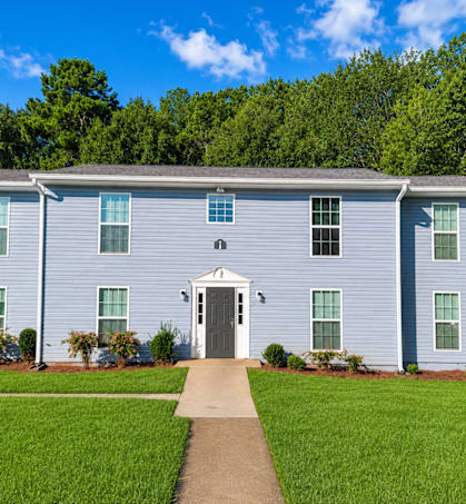 A blue house with a grey roof and a white door.