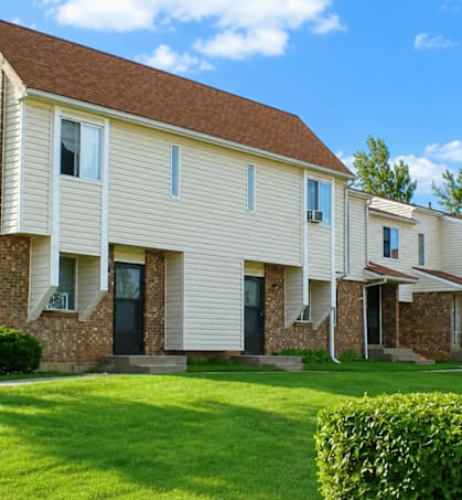 A row of houses with green lawns in front.