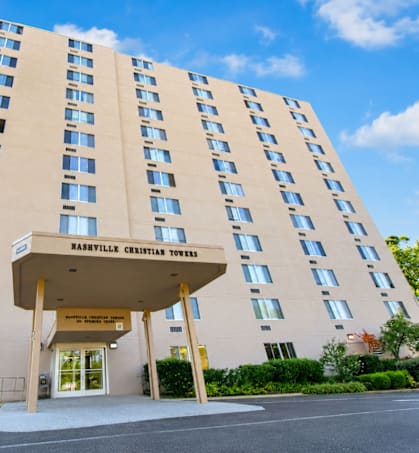 A large building with a beige facade and a sign that reads "Haslev Christian Towers".