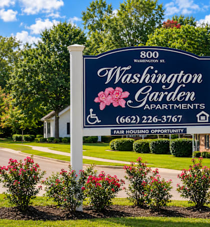 A sign for Washington Garden Apartments stands in front of a building.