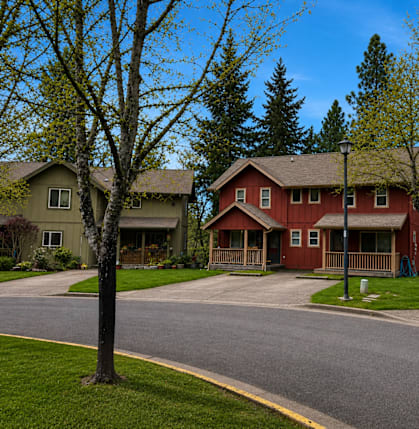 A red house is in the middle of two other houses.