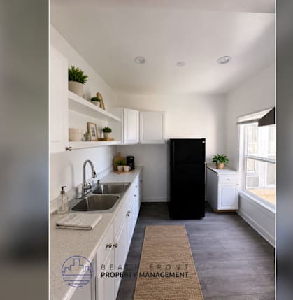 A kitchen with a sink, a refrigerator, and a window.