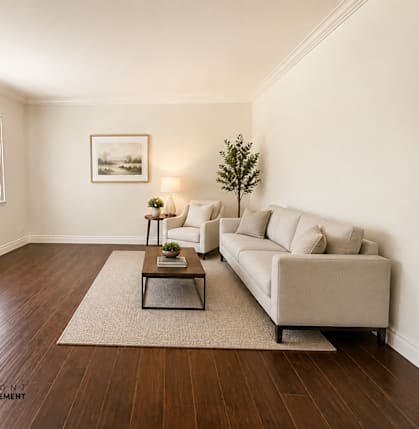 A living room with a couch, coffee table, and a painting on the wall.