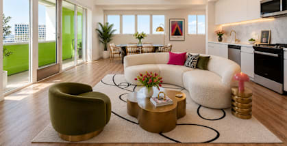 A modern living room with a green armchair and a white sofa.