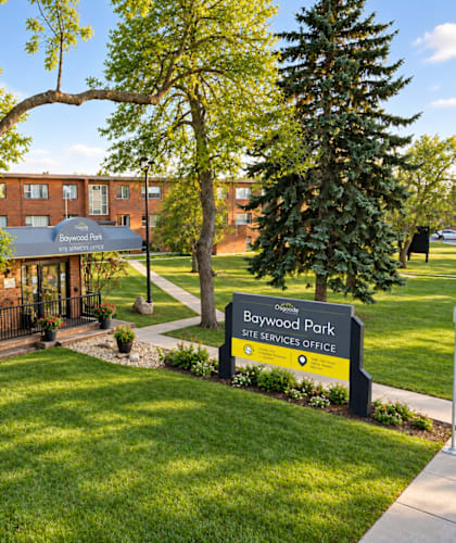 A sign for Baywood Park is in front of a building.