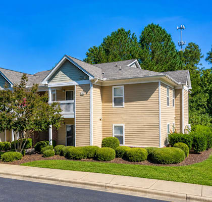 A two-story house with a well-manicured lawn in front.