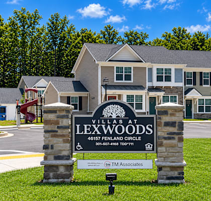 A sign for Villas at Lexwoods in front of a building.