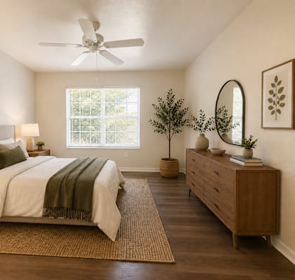 A bedroom with a bed, nightstands, and a ceiling fan.