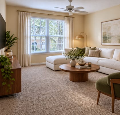 A living room with a white sofa, a green armchair, and a wooden coffee table.