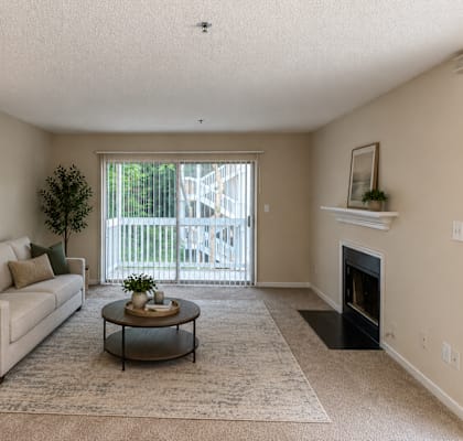 A living room with a couch, coffee table, and fireplace.