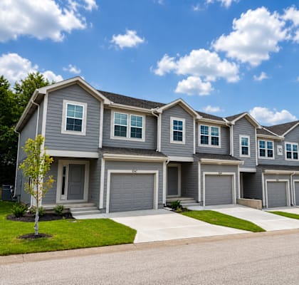 A row of houses with garages and driveways.