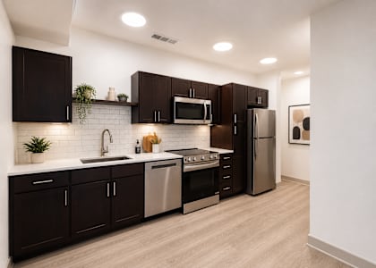 A modern kitchen with dark brown cabinets and stainless steel appliances.