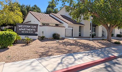 A building with a sign that says Western Sun Apartments.