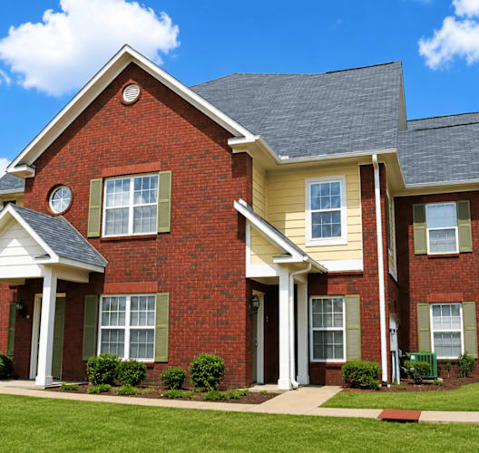 A red brick house with a white porch.