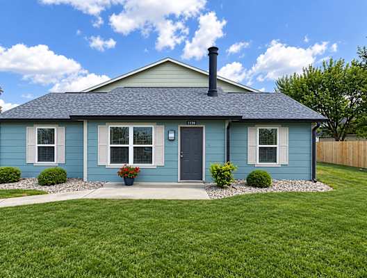 A blue house with a black door and a black chimney.