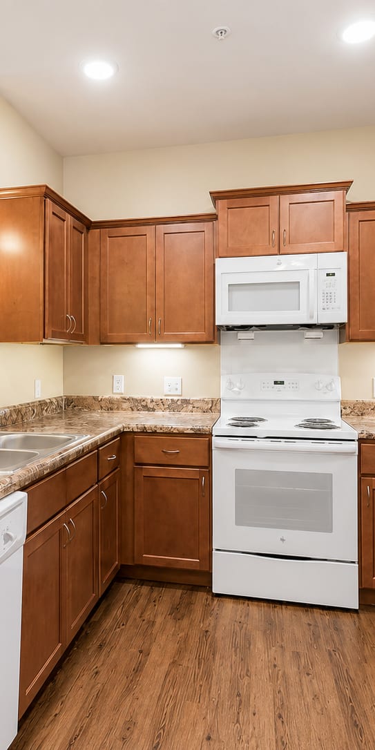 A kitchen with brown cabinets and white appliances.