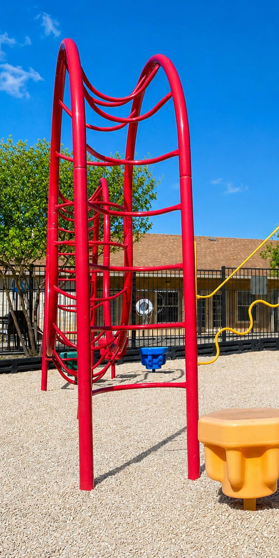 A playground with a red swing set and yellow and blue seesaws.