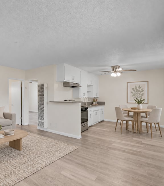 A well-lit, modern kitchen and living room with a dining area.