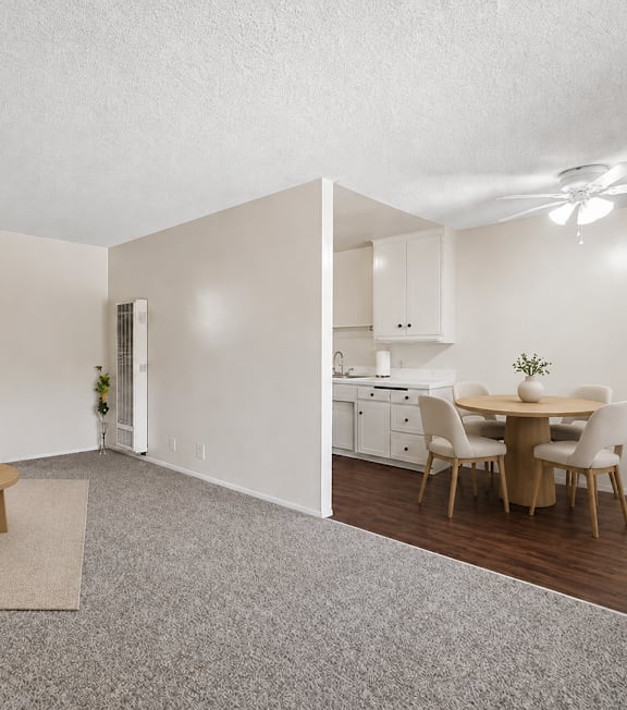 A well-lit, modern kitchen and living room with a dining area.