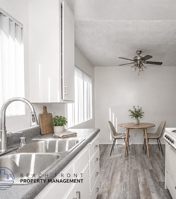 A well-lit, modern kitchen and living room with a dining area.