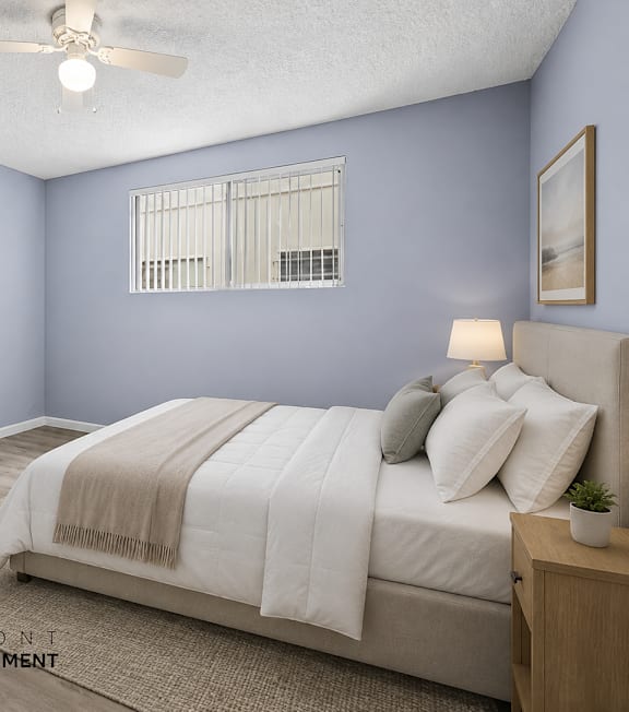 A bedroom with a bed, a ceiling fan, and a window with blinds.