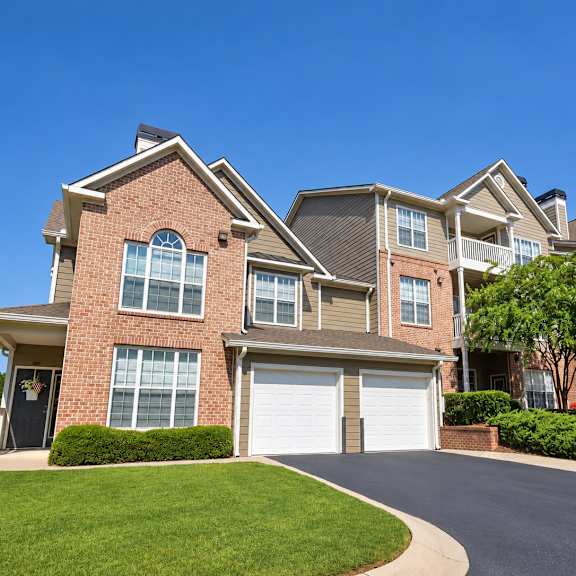 A large, well-maintained house with a driveway in front.