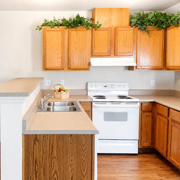 A kitchen with wooden cabinets and a white stove.