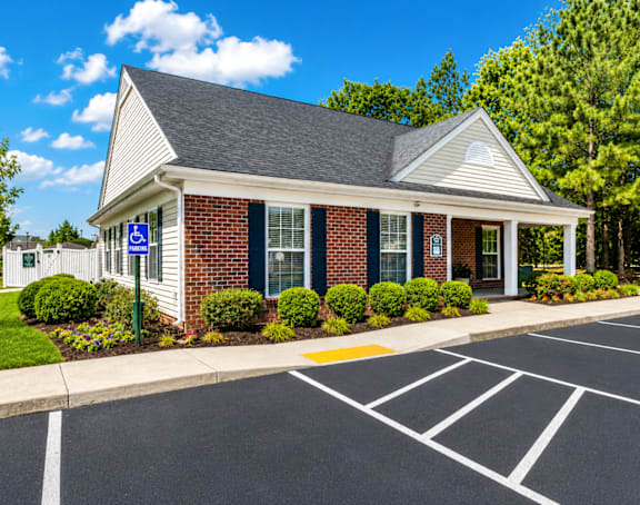 A small building with a parking lot in front of it.