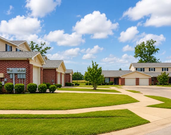 A suburban neighborhood with houses and well-maintained lawns.