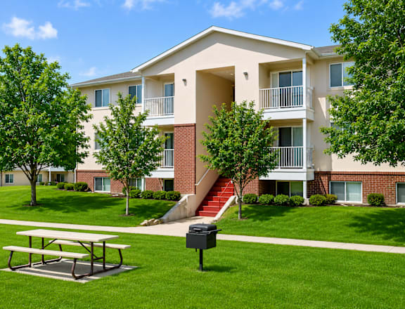 A large apartment complex with a green lawn in front.
