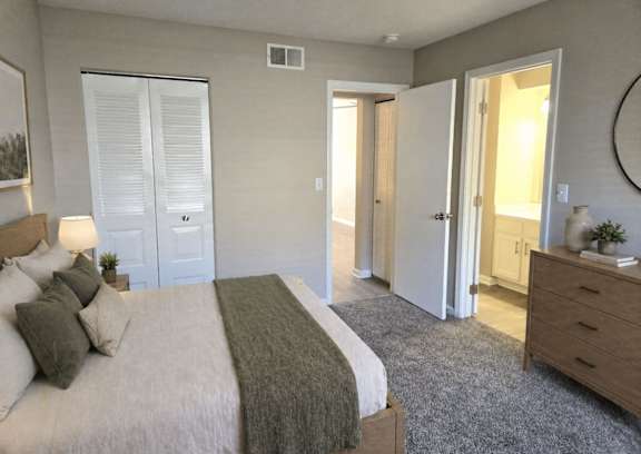 A bedroom with a bed, dresser, and mirror.