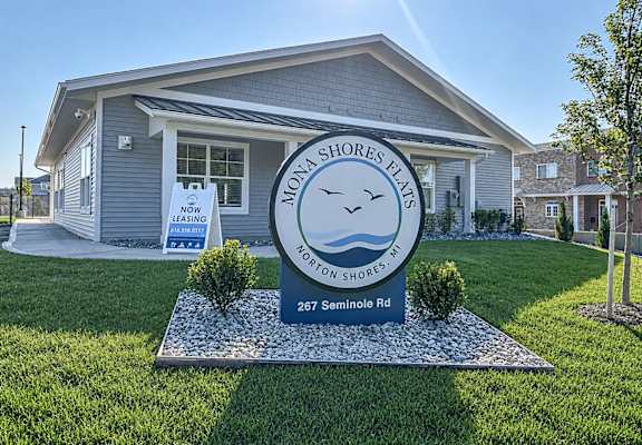 A sign in front of a house that says "Norton Shores Flats" and "267 Seminole Rd".