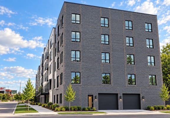 A modern grey building with black garage doors and windows.