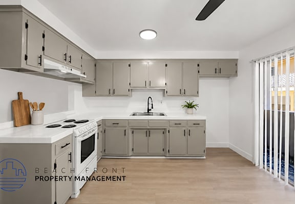 A modern kitchen with a stove top oven and a sink.