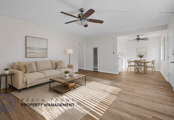 A living room with a couch, a coffee table, and a ceiling fan.