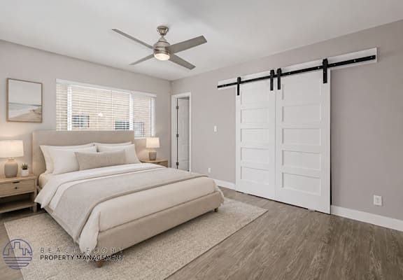 A bedroom with a bed, a ceiling fan, and a sliding door.