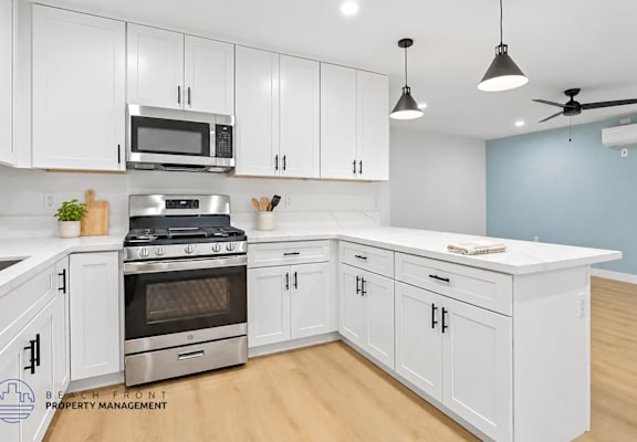 A kitchen with white cabinets and a stainless steel stove.