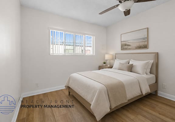 A bedroom with a large bed and a ceiling fan.