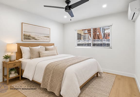 A bedroom with a bed, a ceiling fan, and a window with blinds.