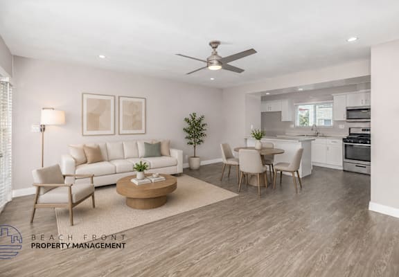 A living room with a white couch, a coffee table, and a dining table with chairs.