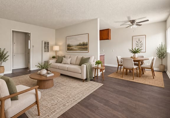 A living room with a white couch, a wooden coffee table, and a painting on the wall.