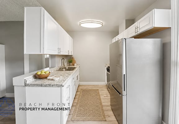 A kitchen with white cabinets and a granite countertop.