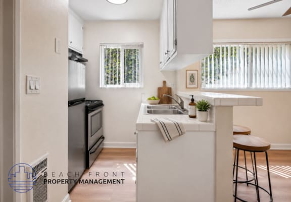 A kitchen with a refrigerator, microwave, and sink.