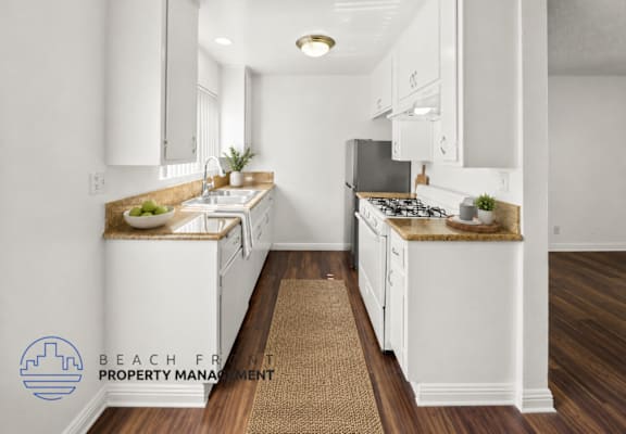 A kitchen with white cabinets and a brown rug on the floor.