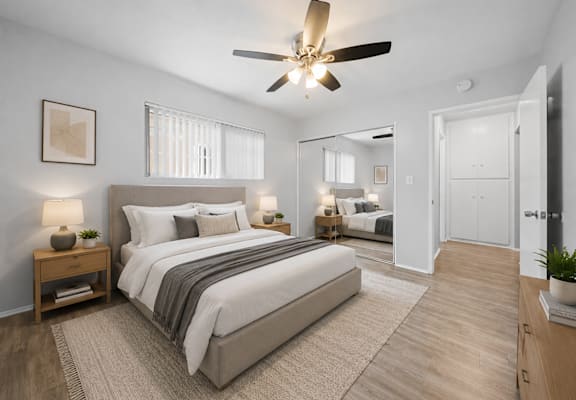 A bedroom with a large bed and a ceiling fan.