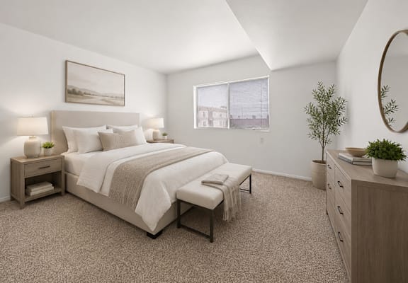 A bedroom with a large bed, nightstands, and a plant.