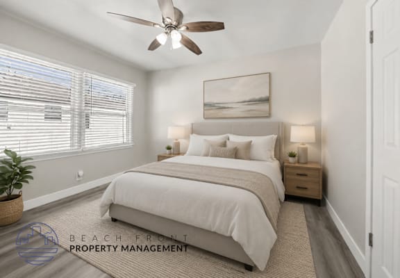 A well-lit bedroom with a large bed and a ceiling fan.