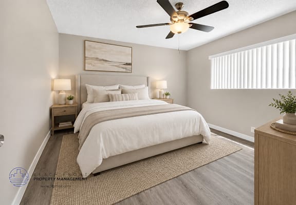 A bedroom with a large bed and a ceiling fan.