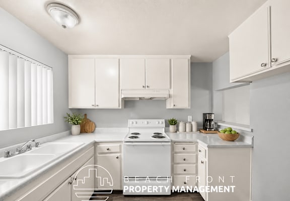A kitchen with white cabinets and a stove top oven.