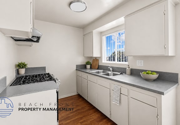 A kitchen with white cabinets and a stove top oven.